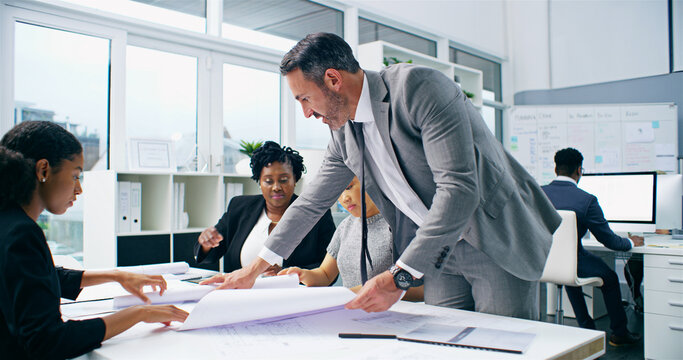 Blueprints, planning and business people in meeting, documents and coworking in modern office. Employees, staff or architecture firm with cooperation, building plans or idea with feedback for project