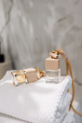 Close up diffuser, air freshener. Modern minimalist bathroom shelves displaying towels, toiletries, and small potted plants, a clean and organized space with a natural and serene atmosphere.