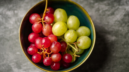 Close-Up of Fresh Green and Red Grapes in a Dark Bowl