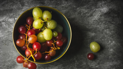 Close-Up of Fresh Green and Red Grapes in a Dark Bowl