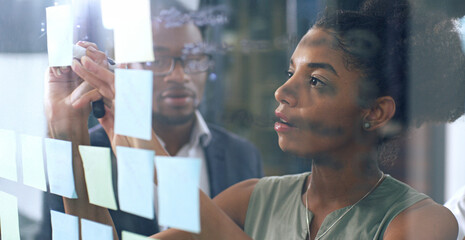 Collaboration, glass and meeting with business people in office for brainstorming or planning. Coaching, development or training and African employee group in workplace for writing with sticky notes