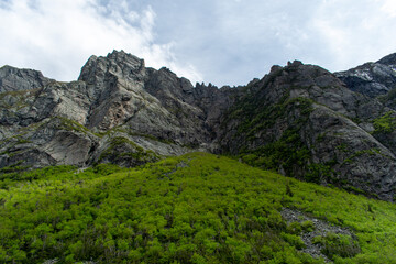 The towering cliff face of Western Brook Pond rises dramatically above the water, showcasing the...