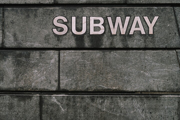 Subway Sign Displayed on a Vibrant Urban Wall