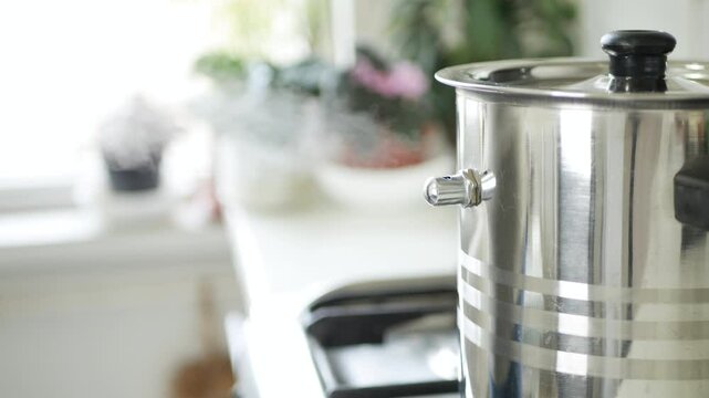 A Pot with Milk Boiling on the Stove, make Steam and Whistle. Traditional Cooking in the Kitchen at Home.