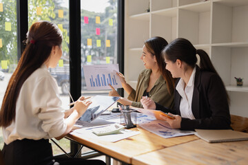 Fototapeta premium Asian businesswoman teamwork working on laptop with finances analysis report at desk in office, business financing, accounting banking, Team of creative and business planning, 