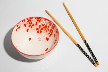 Floral pattern of chinese bowl and chopsticks on white background
