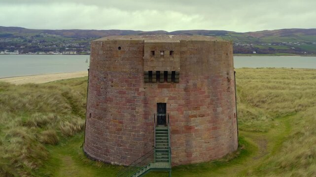 Smooth aerial pullback showcasing the Martello Tower at Magilligan Point, highlighting the entrance of the tower