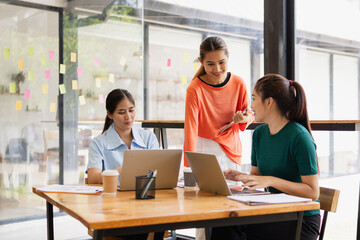 Fototapeta premium Technology and financial advisory services concept. Businesswoman teamwork and working on digital laptop computer with advisor showing plan of investment to clients at table office. Digital marketing.