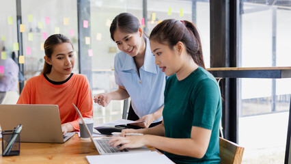 Fototapeta premium group of asian businesswoman working on laptop with finances analysis report at desk in office, business financing, accounting banking, Team of creative and business planning, 