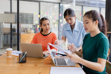 group of asian businesswoman working on laptop with finances analysis report at desk in office, business financing, accounting banking, Team of creative and business planning, 