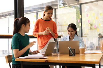 Fototapeta premium group of asian businesswoman working on laptop with finances analysis report at desk in office, business financing, accounting banking, Team of creative and business planning, 