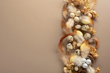 Easter composition with quail eggs, feathers, and dried flowers.