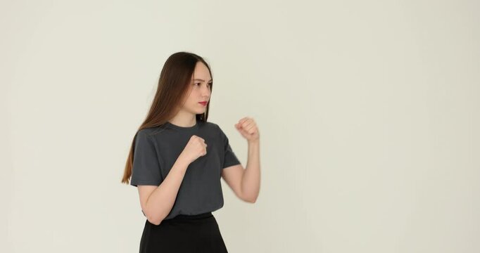 Woman demonstrates basic striking technique for self-defense against white background