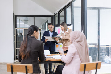 Obraz premium Team of Asian business people and working together in office, Startup projects and business presentation at meeting room.