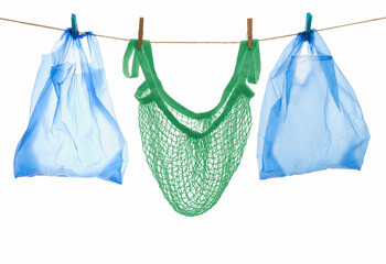 sustainable cotton shopping net and disposable plastic bags put on a line, sustainability versus...