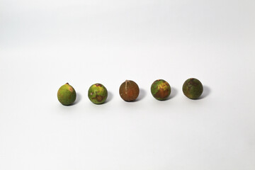 Green lime fruits on isolated white background. Sliced and unsliced.