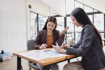 young asian businesswoman working on laptop with finances analysis report at desk in office, business financing, accounting banking,