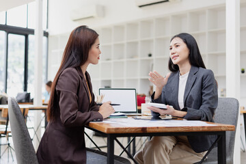 Asian businesswoman working on laptop with finances analysis report at desk in office, business financing, accounting banking,