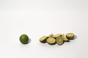 Green lime fruits on isolated white background. Sliced and unsliced.