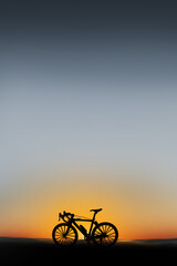 Shadow bicycle parked at beach on sunset background. Vacation in summer