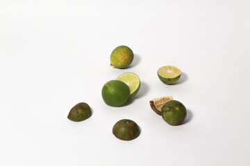 Green lime fruits on isolated white background. Sliced and unsliced.