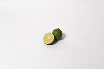 Green lime fruits on isolated white background. Sliced and unsliced.
