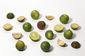 Green lime fruits on isolated white background. Sliced and unsliced.