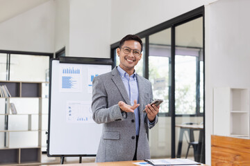 Fototapeta premium Happy asian businessman standing in office, Excited male person, Employee in achievement,&nbsp;