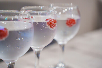 glasses with sparkling water and raspberries. 