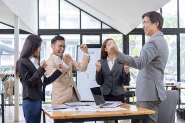 Confident team of Asian business people stands at office. 