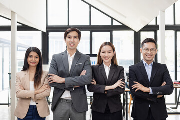 Confident team of Asian business people stands at office. 