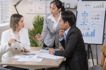 Asian business teamwork working on digital tablet with analysis report and advisor showing plan, Financial analysis and Marketing teamwork concept.
