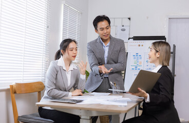 Asian business teamwork working on digital tablet with analysis report and advisor showing plan, Financial analysis and Marketing teamwork concept.
