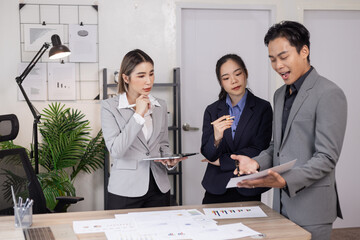 Asian business teamwork working on digital tablet with analysis report and advisor showing plan, Financial analysis and Marketing teamwork concept.