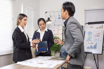 Asian business teamwork working on digital tablet with analysis report and advisor showing plan, Financial analysis and Marketing teamwork concept.