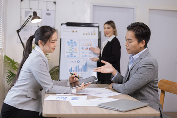 Asian business teamwork working on digital tablet with analysis report and advisor showing plan, Financial analysis and Marketing teamwork concept.