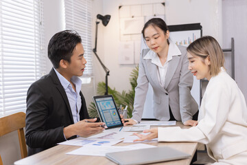 Asian business teamwork working on digital tablet with analysis report and advisor showing plan, Financial analysis and Marketing teamwork concept.
