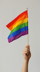 Fototapeta premium hand holding colorful rainbow gay flag, symbol of lgbt people, diversity of genders love,romance,
