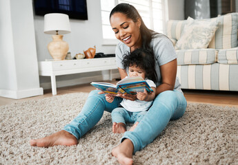 Happy mother, baby and reading with book on floor for story, bonding or early childhood development at home. Mom, child or kid with smile for novel, learning or education in living room at house
