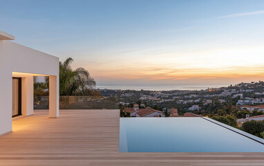 Fototapeta premium Modern villa with infinity pool, stunning sunset, and coastal views in a lush area