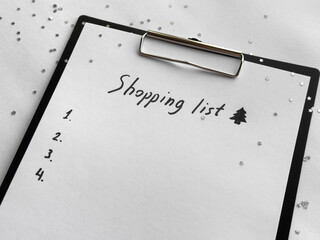 Festive shopping list on clipboard with holiday decorations and stars