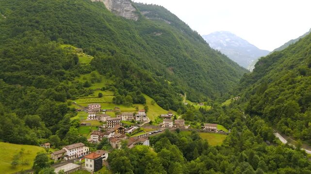A quiet town set against the powerful Dolomites, seen by drone.