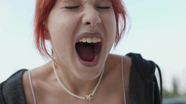Young girl angry and screaming. Upset girl screaming, teenager with facial piercing. shock and emotional breakdown, depression.