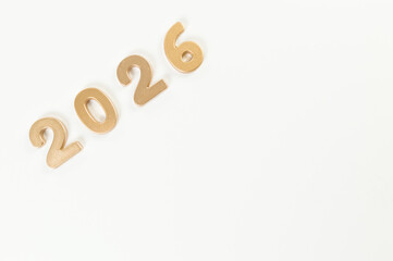 2026 Happy New Year. Top view of gold numbers on white background. Copy space, flat lay.