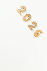 2026 Happy New Year. Top view of gold numbers on white background. Copy space, flat lay.