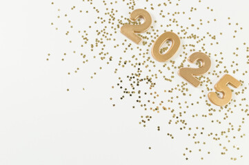 2025 Happy New Year. Top view of gold numbers, gold stars confetti on white background. Copy space, flat lay.
