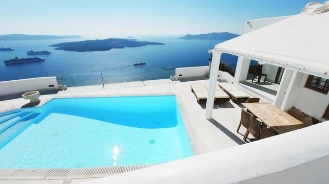 White architecture in Santorini island, Greece. Luxury swimming pool with blue water. Blue sea and the blue sky at sunny day. Luxury resort. Travel and summer vacation concept. 
