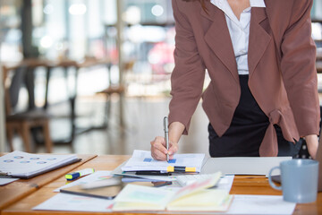Closeup shot of business woman's hand using pen and writing in computer notebook business calculations or a female student using a computer The phone works for
 Exam preparation, presentations