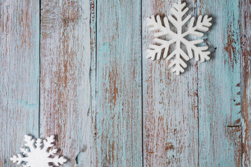Fototapeta premium White decorative snowflakes on blue wooden background, copy space