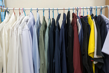 Collection of clothes hanging on rack at home
